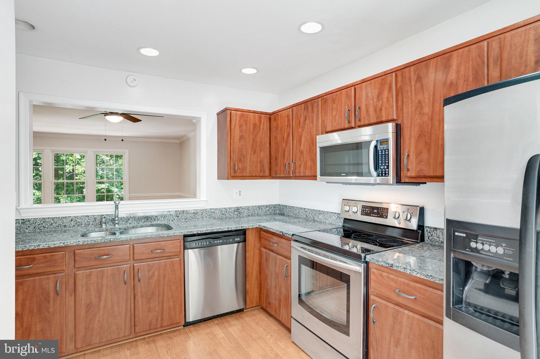 7918 Pebble Brook Court Springfield, VA 22153 - Photo 4 of 28 a kitchen with stainless steel appliances granite countertop a stove a sink and a microwave