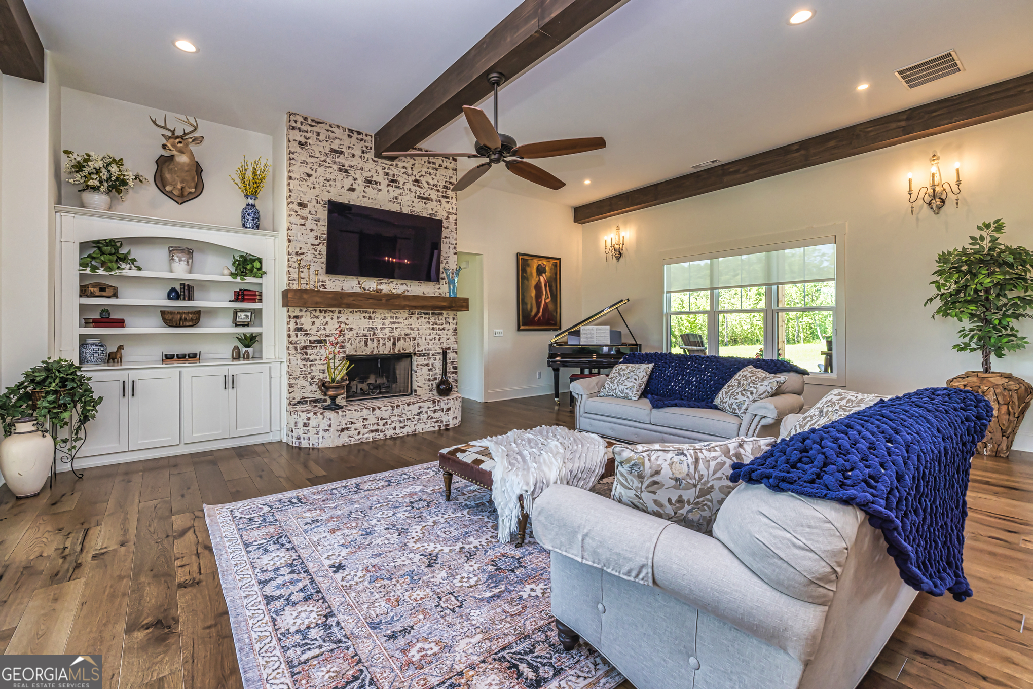 11084 Mt Carmel Road Senoia, GA 30276 - Photo 9 of 136 a living room with furniture a flat screen tv and a fireplace