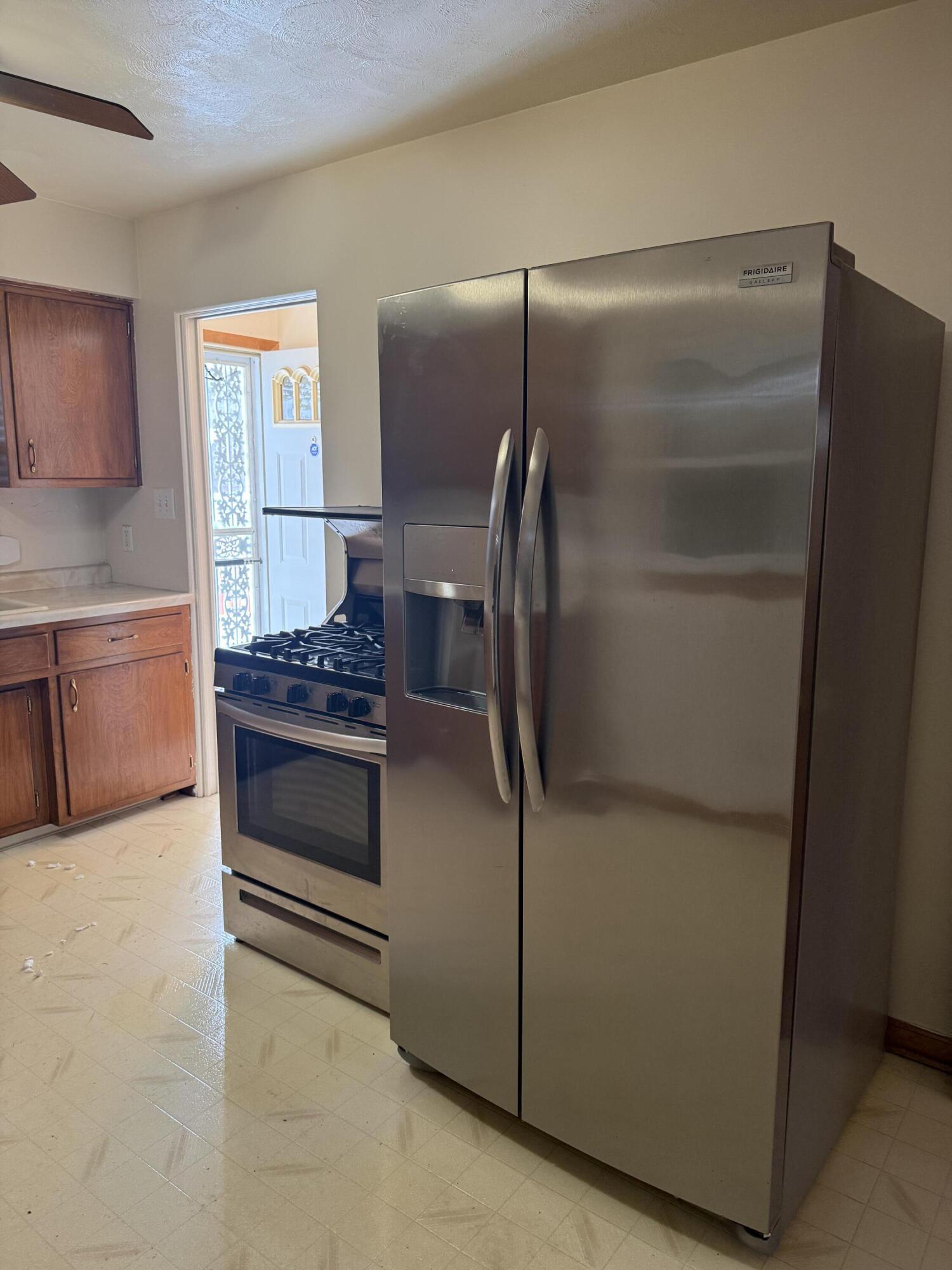 562 Dallas Street Gary, IN 46406 - Photo 2 of 15 a kitchen with a refrigerator and a stove top oven