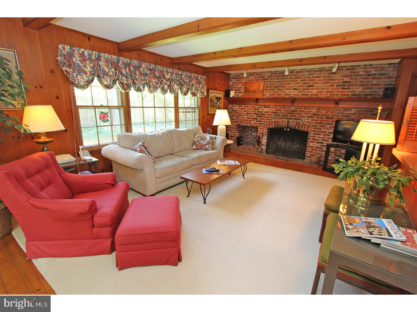 1664 Weedon Road Wayne, PA 19087 - Photo 10 of 24 a living room with furniture a fireplace and a floor to ceiling window
