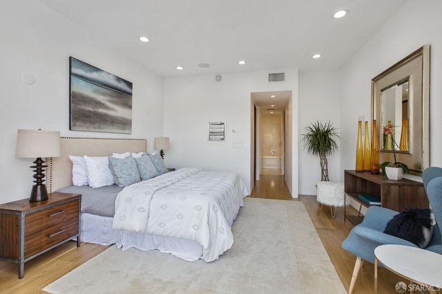 a spacious bedroom with a large bed and a chandelier