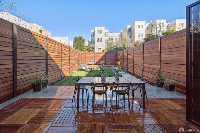 a balcony with wooden floor table and chairs