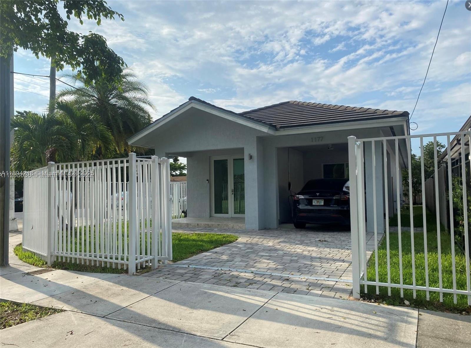 a view of a house with a small yard and wooden fence