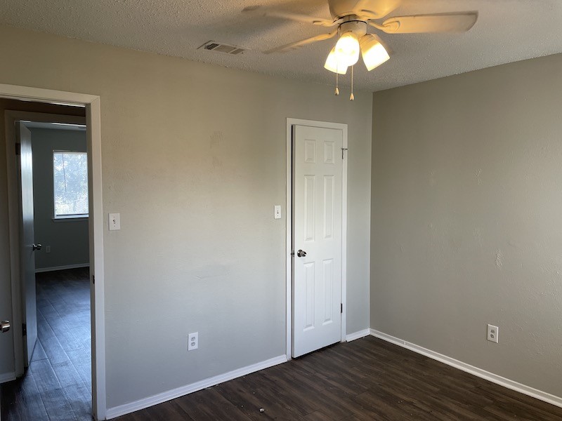 8401 Colony Loop Drive, Unit D Austin, TX 78724 - Photo 11 of 18 a view of an empty room with wooden floor and a ceiling fan