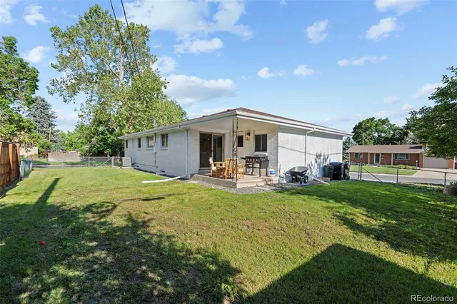 a view of a house with backyard and sitting area