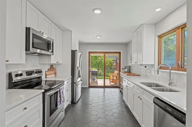 a kitchen with stainless steel appliances a sink stove top oven and refrigerator