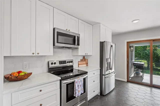 a kitchen with stainless steel appliances granite countertop a refrigerator stove and sink