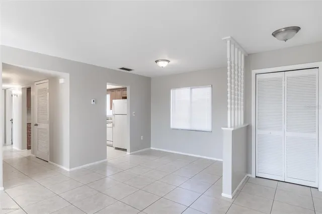 a view of an empty room with window and closet area