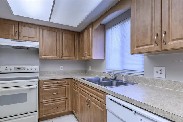 a kitchen with granite countertop cabinets and white appliances