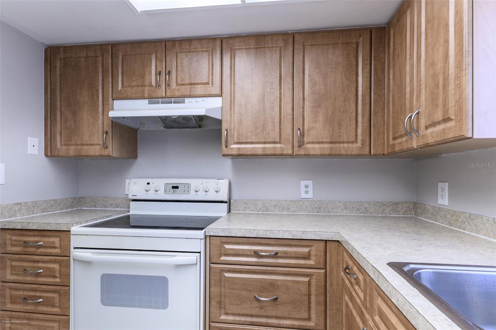 1204 Spanish Cay Lane, Unit B Punta Gorda, FL 33950 - Photo 21 of 45 a kitchen with granite countertop cabinets and white appliances