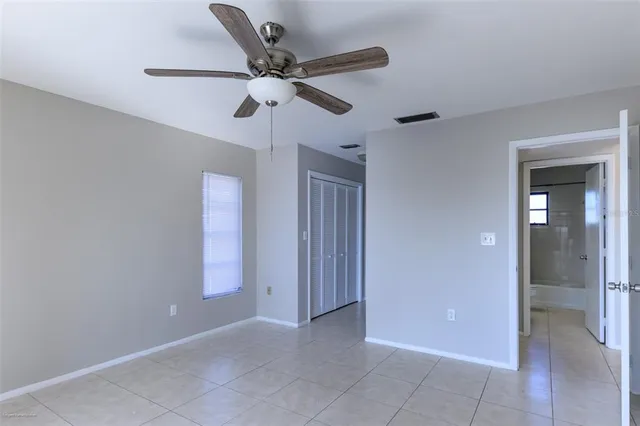 a view of a hallway with a white cabinet and a bathroom