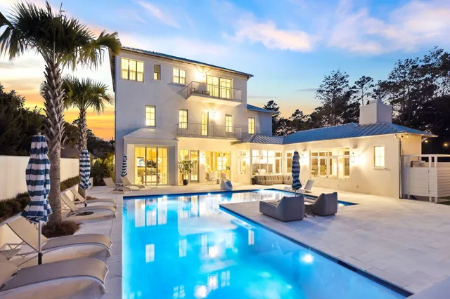 a living room with furniture a fireplace and a chandelier