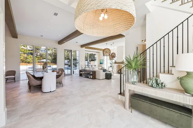 a dining hall with stainless steel appliances kitchen island granite countertop a table chairs and a view of living room