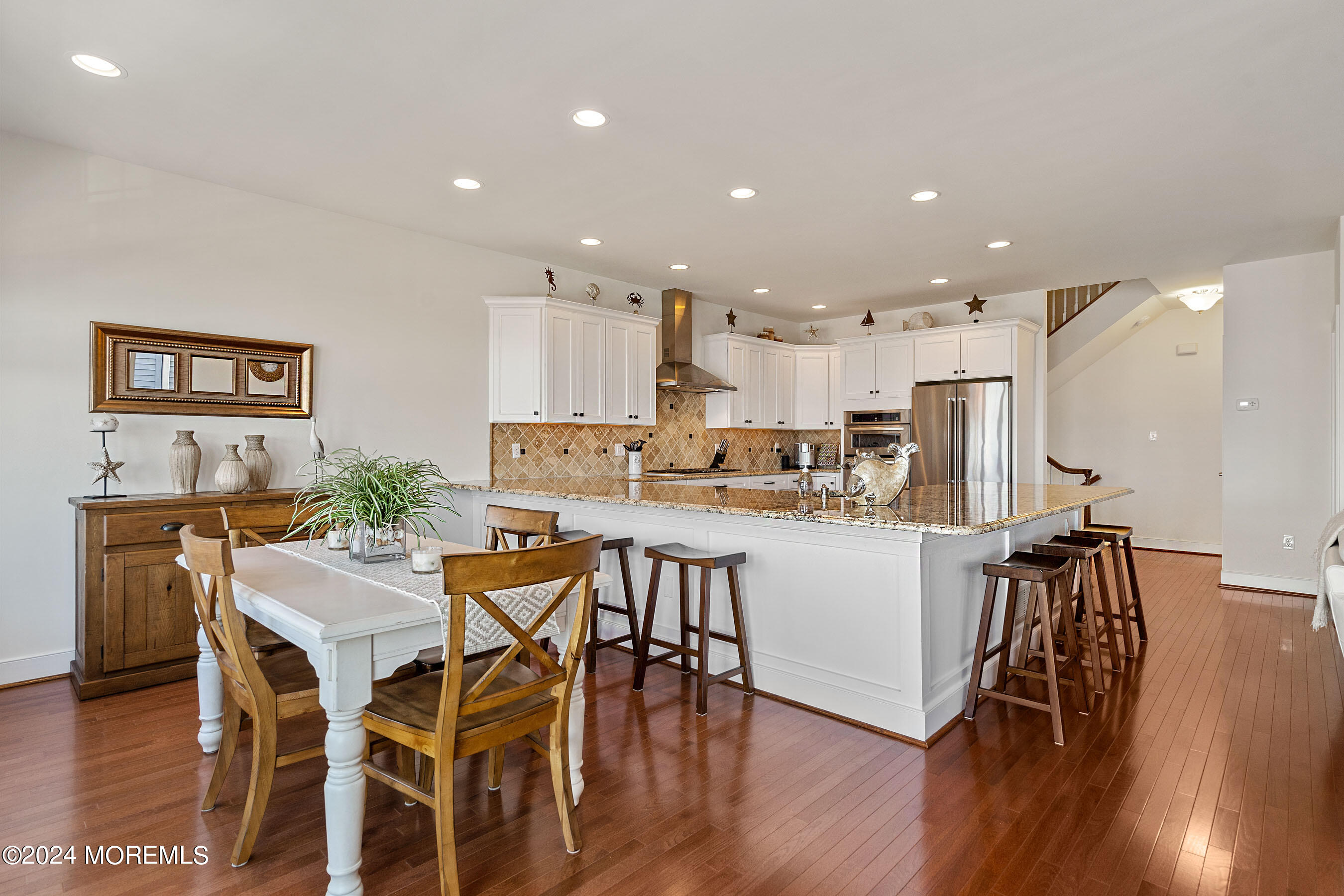556 Riverside Drive Manasquan, NJ 08736 - Photo 16 of 42 a kitchen with a dining table chairs wooden floor cabinets and appliances
