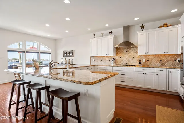 a kitchen with granite countertop white cabinets and stainless steel appliances