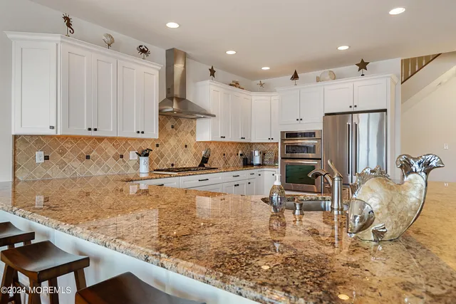 a kitchen with stainless steel appliances granite countertop a sink refrigerator and cabinets