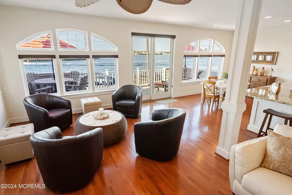 a living room with furniture a large window and wooden floor