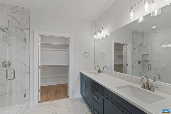 a bathroom with a double vanity sink a mirror and a shower