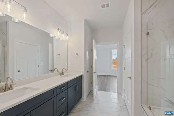 a bathroom with a double vanity sink shower and a mirror