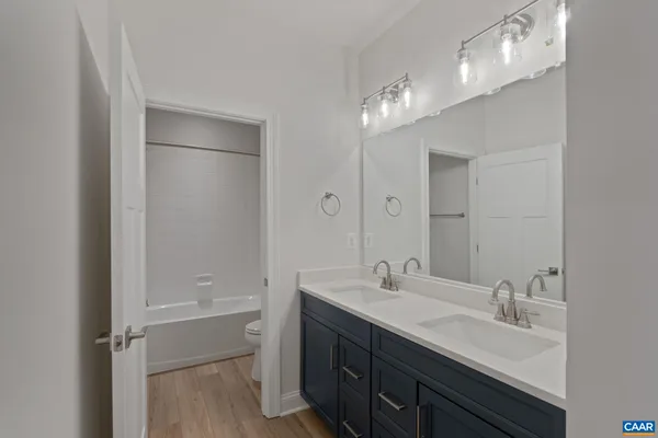 a bathroom with a double vanity sink mirror and toilet