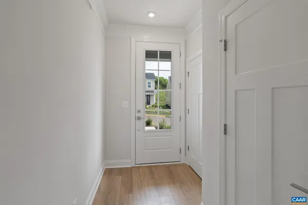 a view of a hallway with wooden floor and a small space