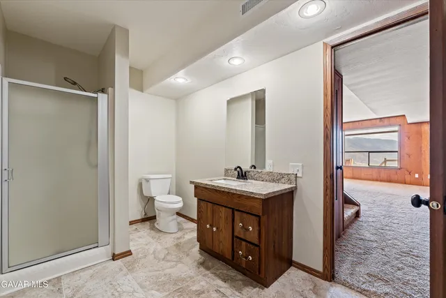 a view of an empty room with a fireplace and windows