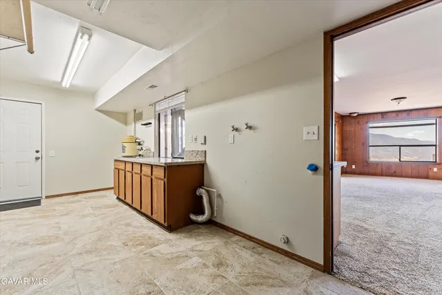 a view of a house with a barbeque and large trees
