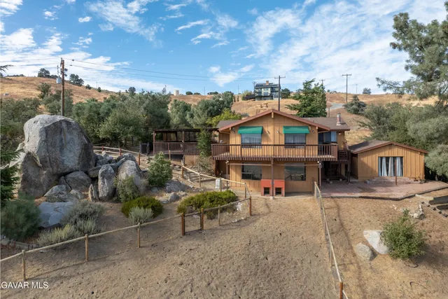 an aerial view of a house with a yard and large trees