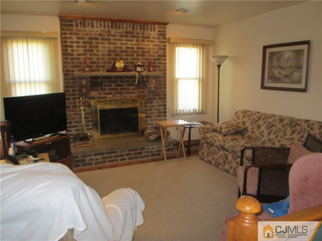 907 New Dover Road Edison, NJ 08820 - Photo 10 of 21 a living room with furniture a flat screen tv and a fireplace