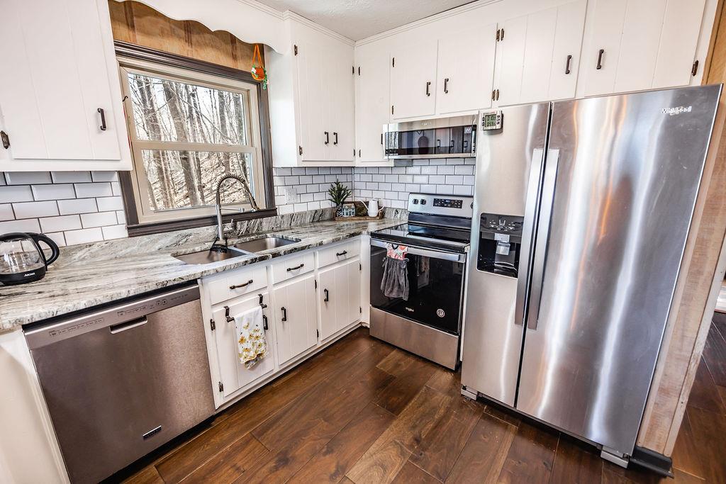 1006 Chestnut Cove Trail Jasper, GA 30143 - Photo 8 of 33 a kitchen with stainless steel appliances a sink a stove a refrigerator and cabinets
