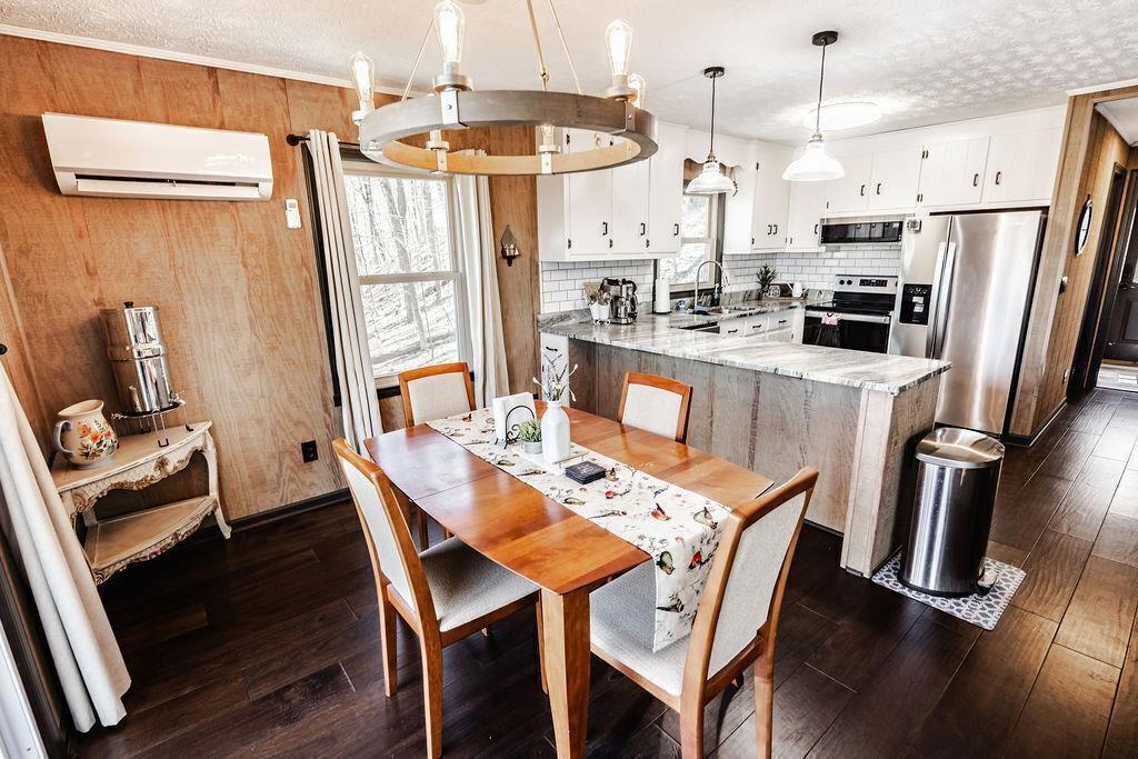 1006 Chestnut Cove Trail Jasper, GA 30143 - Photo 8 of 33 a dining room with stainless steel appliances kitchen island granite countertop a refrigerator a stove a microwave oven a dining table and chairs with wooden floor
