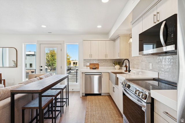 51 East 200 North, Unit 3 Bountiful, UT 84010 - Photo 8 of 27 Kitchen with stainless steel appliances, light wood-style flooring, light stone counters, backsplash, and modern cabinets