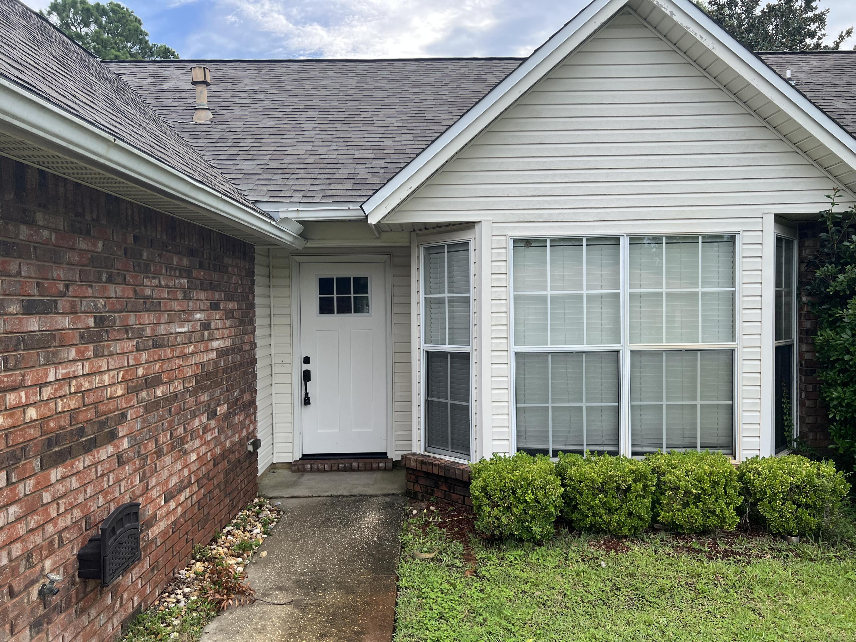 5 Neptune Drive Mary Esther, FL 32569 - Photo 2 of 32 a front view of a house with a garden