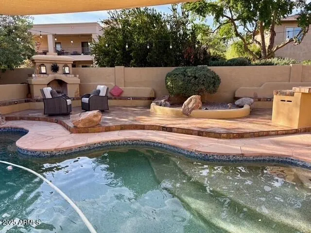 a backyard of a house with fireplace table and chairs