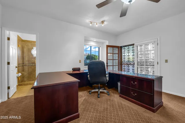 a bedroom with a bed and a chandelier fan