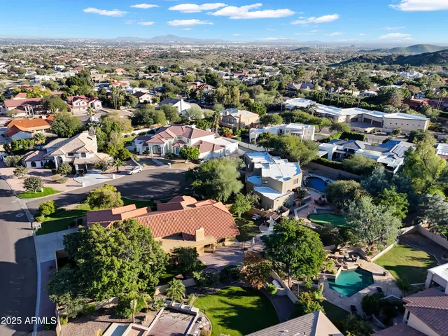 an aerial view of residential houses with outdoor space and trees