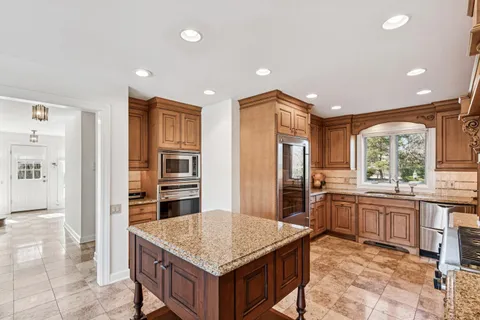 a large kitchen with kitchen island granite countertop a large counter top and appliances