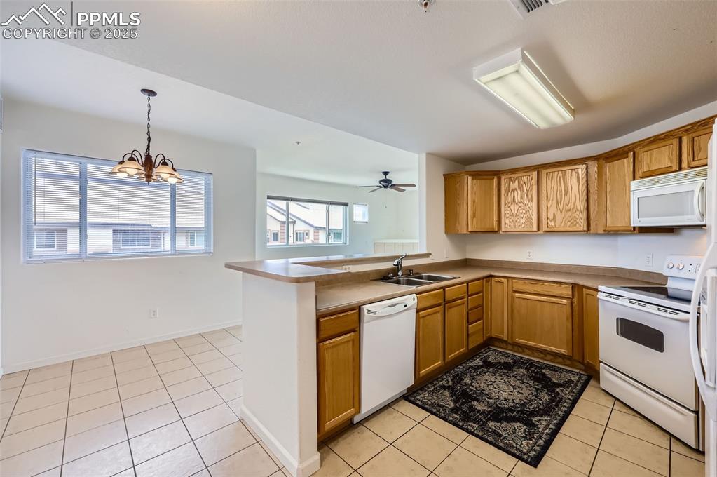 3755 Hartsock Lane, Unit 203 Colorado Springs, CO 80917 - Photo 12 of 43 a kitchen with a stove a sink and a refrigerator