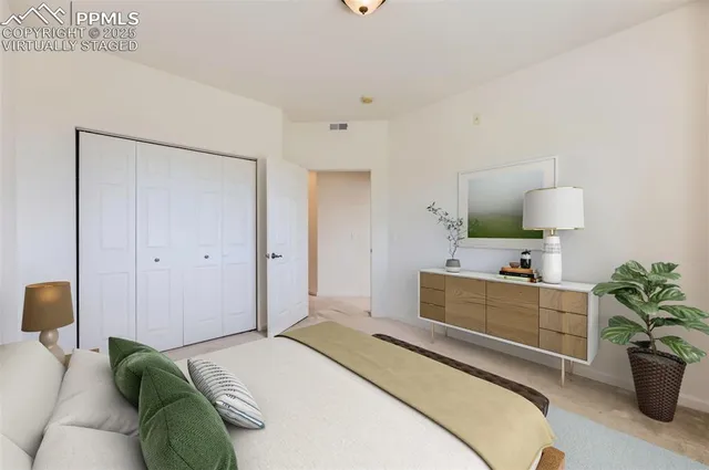 a bedroom with a bed and a potted plant