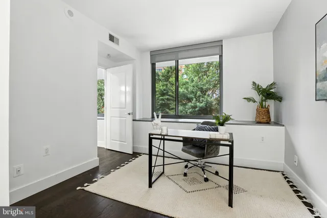 a view of a workspace with furniture and a window