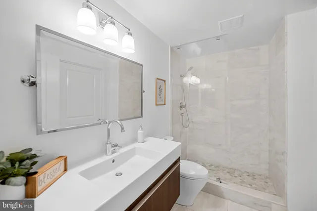 a bathroom with a sink a toilet and shower