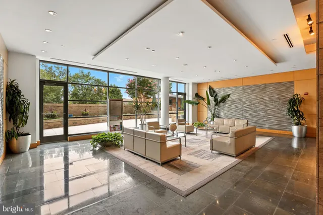 a view of a living room with a floor to ceiling window and an entryway