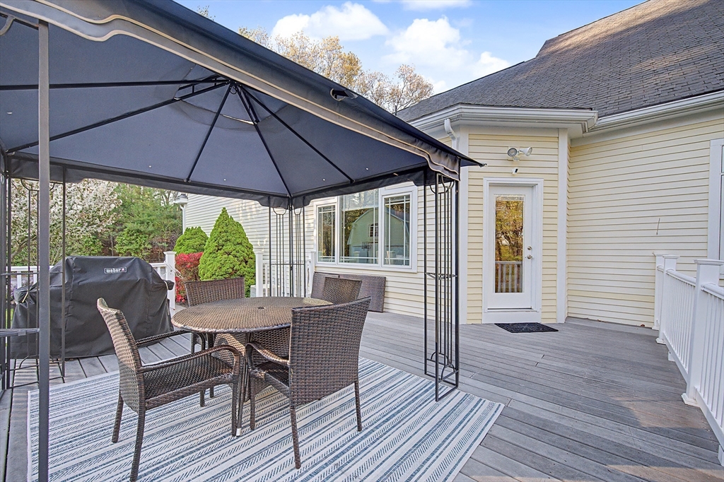 270 Mendon Road Sutton, MA 01590 - Photo 39 of 42 a patio with wooden floor a yard a table and chairs