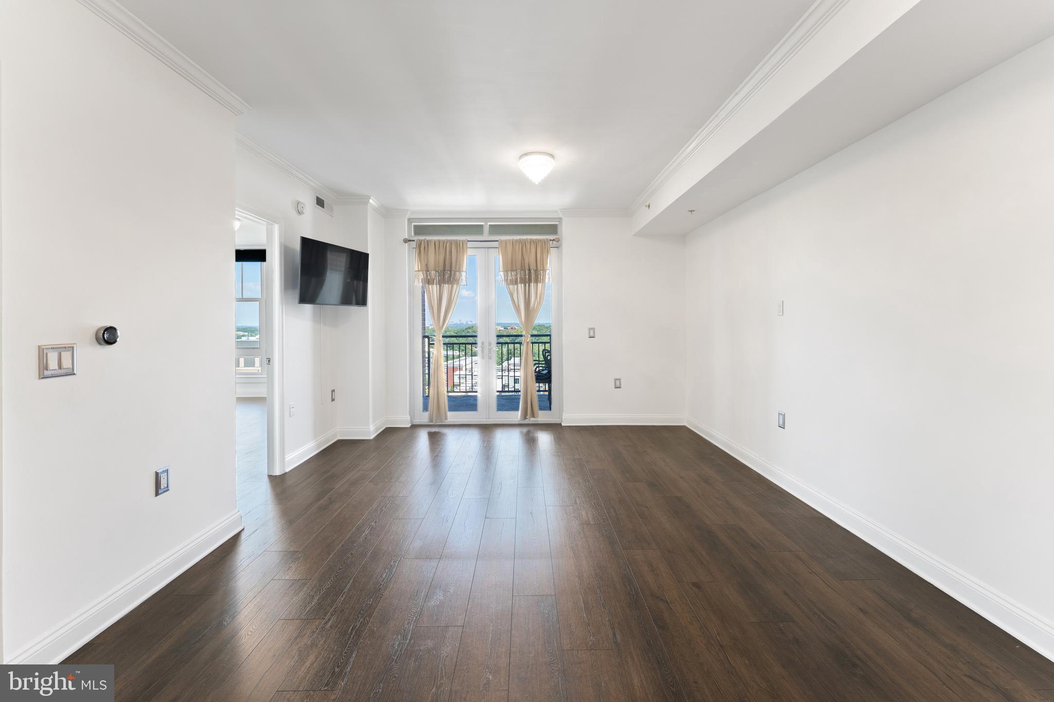 11760 Sunrise Valley Drive, Unit 809 Reston, VA 20191 - Photo 4 of 15 an empty room with wooden floor and windows