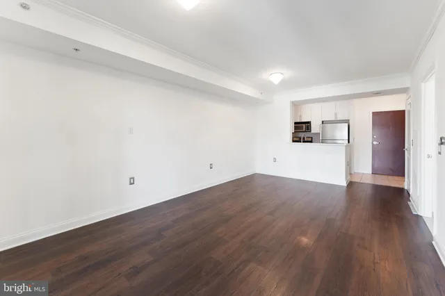 a view of a room with wooden floors and white walls