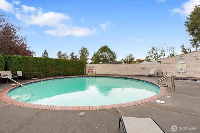 a view of a swimming pool with a yard and sitting area