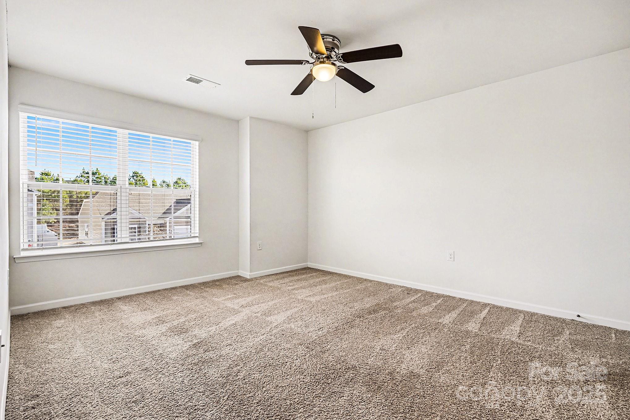 3224 Hawksbill Street Southwest Concord, NC 28027 - Photo 25 of 35 an empty room with windows and ceiling fan