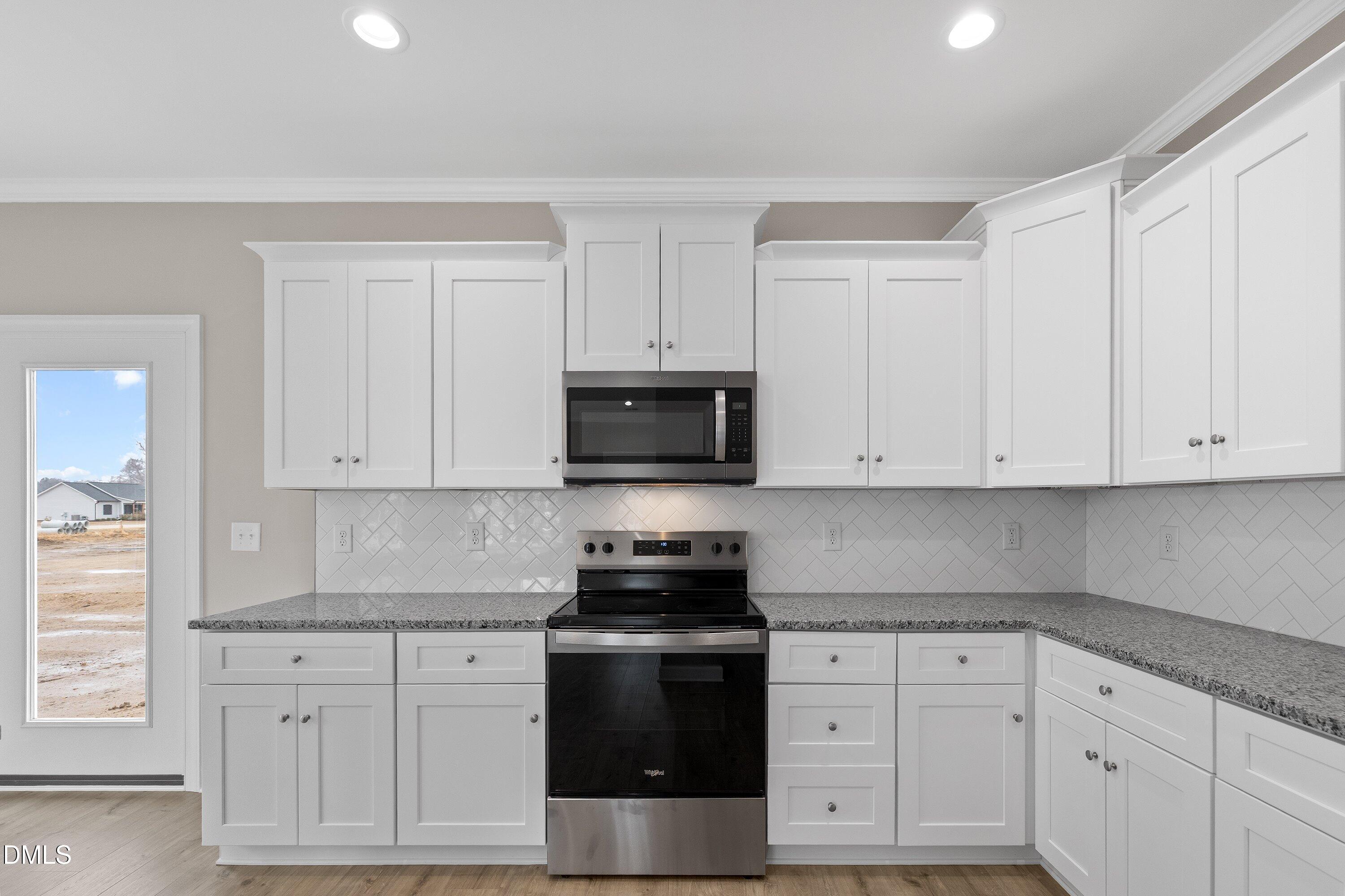 926 Micro Road West Selma, NC 27576 - Photo 26 of 41 a kitchen with white cabinets and stainless steel appliances
