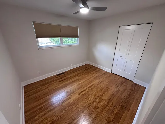 a view of empty room with window and wooden floor