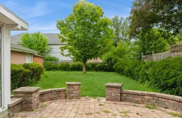 a view of a backyard with chair and garden